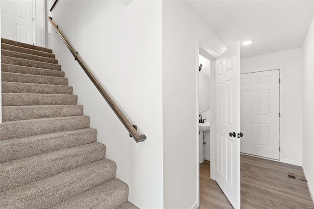 staircase with hardwood / wood-style floors