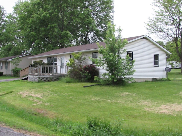 view of front facade with a wooden deck and a front lawn