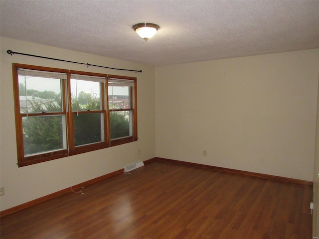 unfurnished room featuring dark hardwood / wood-style floors and a textured ceiling