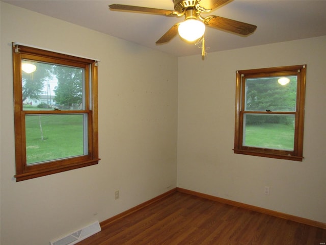 spare room featuring wood-type flooring, ceiling fan, and a healthy amount of sunlight