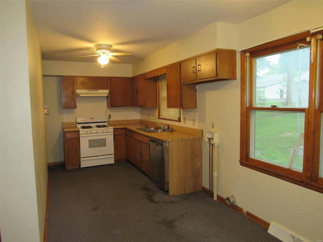 kitchen with dark colored carpet, ceiling fan, white range with gas cooktop, tasteful backsplash, and stainless steel dishwasher