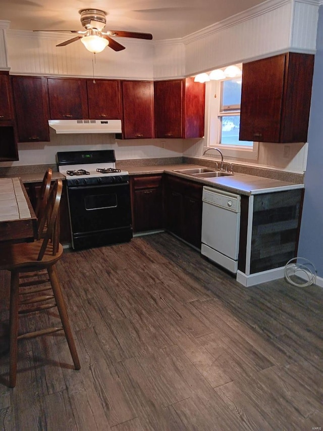 kitchen featuring dark hardwood / wood-style flooring, white appliances, sink, and crown molding