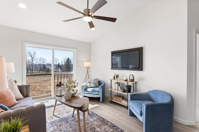 living room featuring light hardwood / wood-style flooring, ceiling fan, and vaulted ceiling