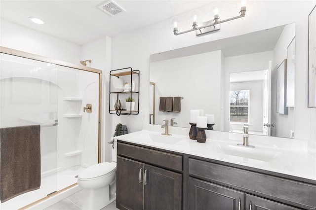 bathroom featuring a shower with door, toilet, tile floors, and dual vanity