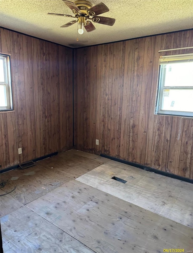 unfurnished room featuring a healthy amount of sunlight, a textured ceiling, and ceiling fan