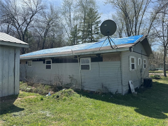 view of property exterior with a yard and central air condition unit