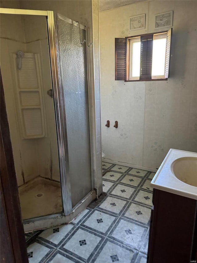 bathroom featuring tile flooring, vanity, and a shower with door