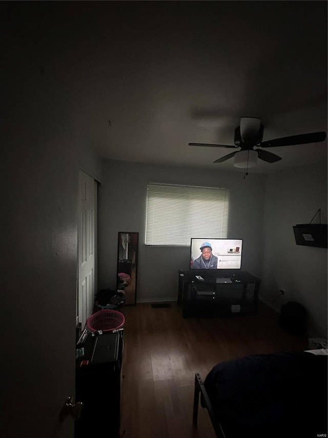 bedroom with dark hardwood / wood-style flooring and ceiling fan