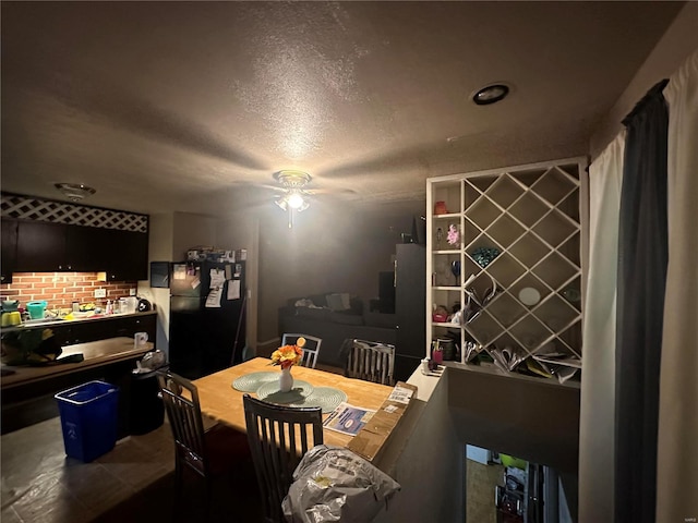 dining space featuring ceiling fan and a textured ceiling