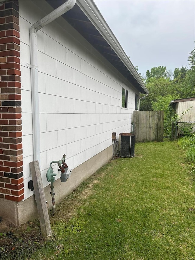 view of side of property with central AC and a yard