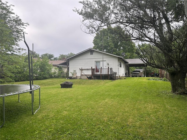 view of yard with a fire pit and a trampoline