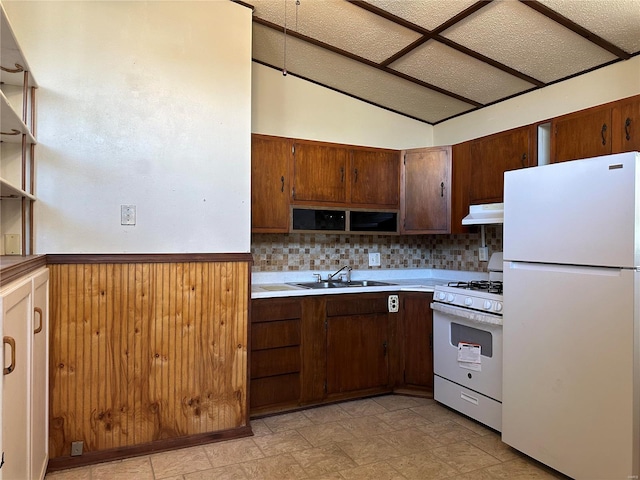 kitchen with vaulted ceiling, light tile flooring, tasteful backsplash, sink, and white appliances