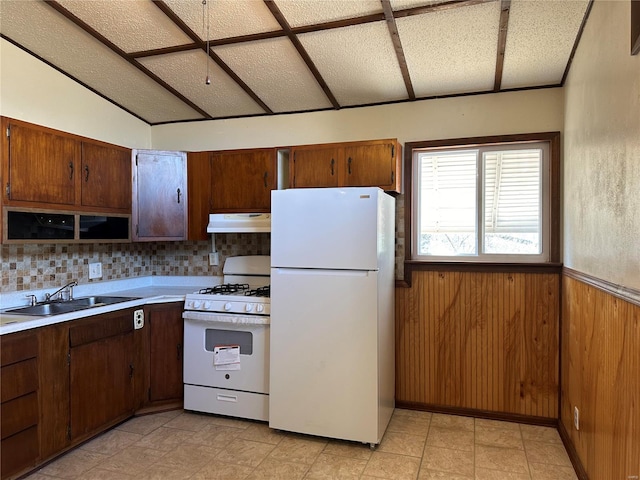 kitchen featuring sink, light tile flooring, white appliances, and backsplash