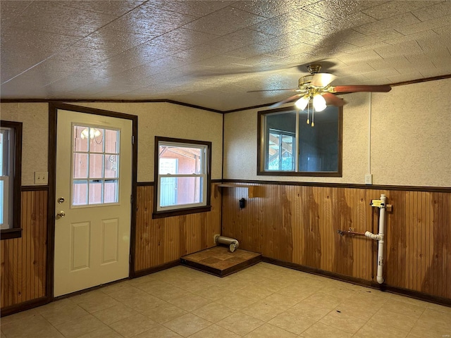 foyer with ceiling fan, ornamental molding, and light tile floors