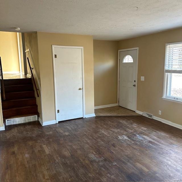 entryway with dark hardwood / wood-style flooring and a textured ceiling