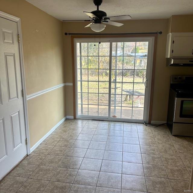 unfurnished dining area with ceiling fan and light tile patterned floors