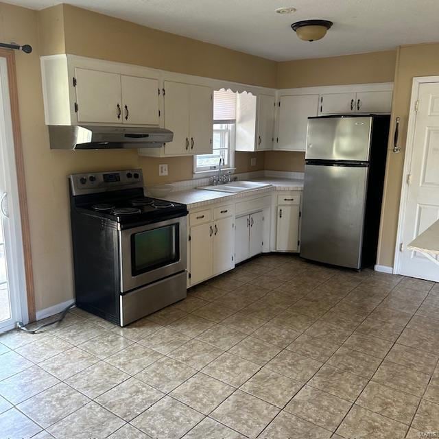 kitchen with sink, white cabinetry, stainless steel appliances, and light tile patterned floors