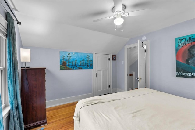 bedroom with ceiling fan, hardwood / wood-style floors, and lofted ceiling