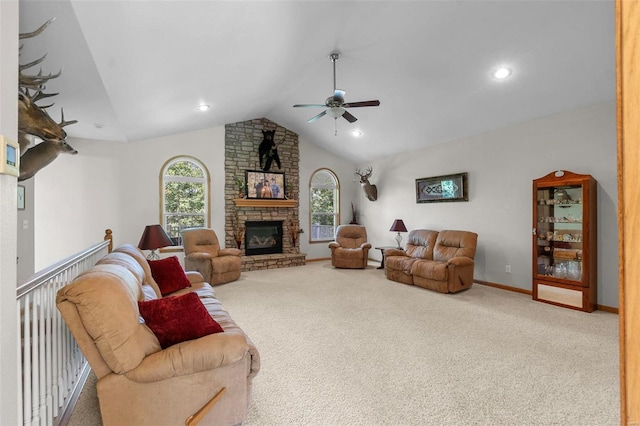 living room with ceiling fan, a stone fireplace, carpet floors, and vaulted ceiling