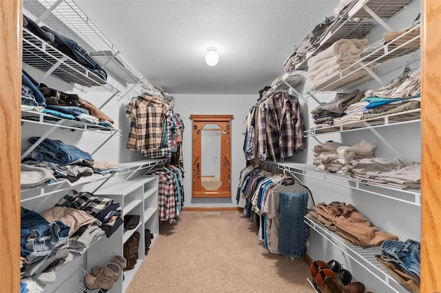 walk in closet featuring light carpet