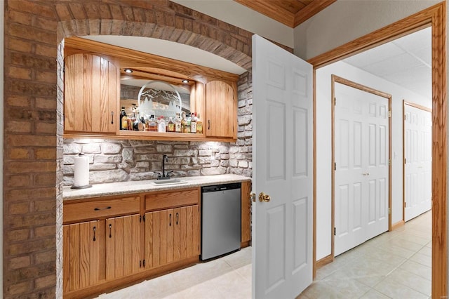 kitchen featuring dishwasher, light tile patterned floors, ornamental molding, and sink