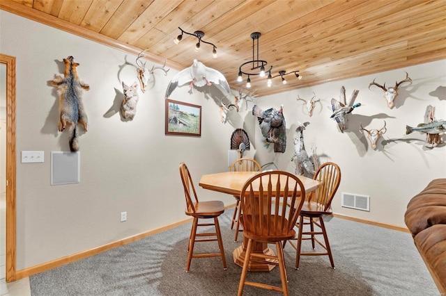 carpeted dining space with crown molding, wood ceiling, and rail lighting