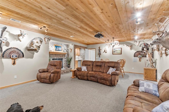 carpeted living room with a stone fireplace and wood ceiling