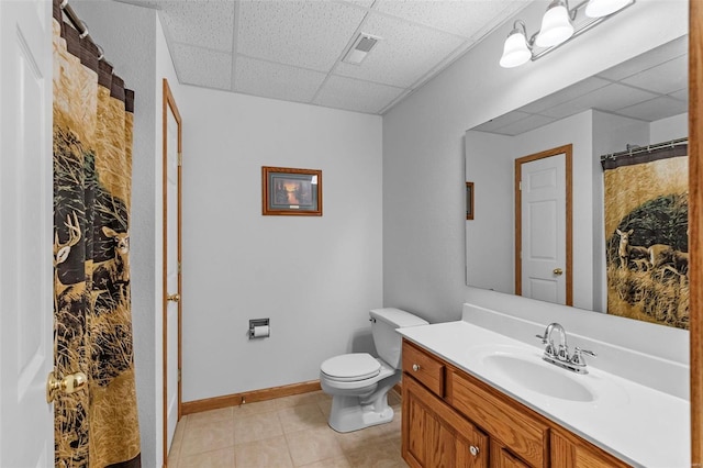 bathroom featuring tile patterned floors, a paneled ceiling, vanity, and toilet