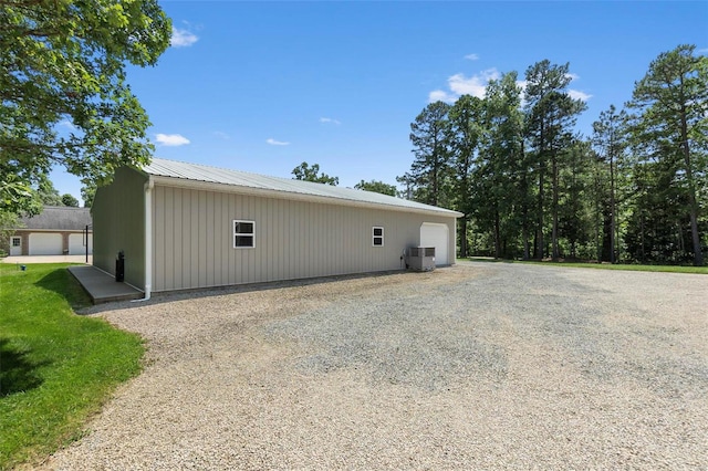 view of side of property featuring central AC, an outbuilding, and a garage