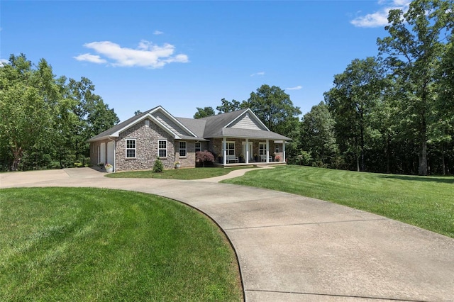 view of front of property with a porch, a garage, and a front lawn