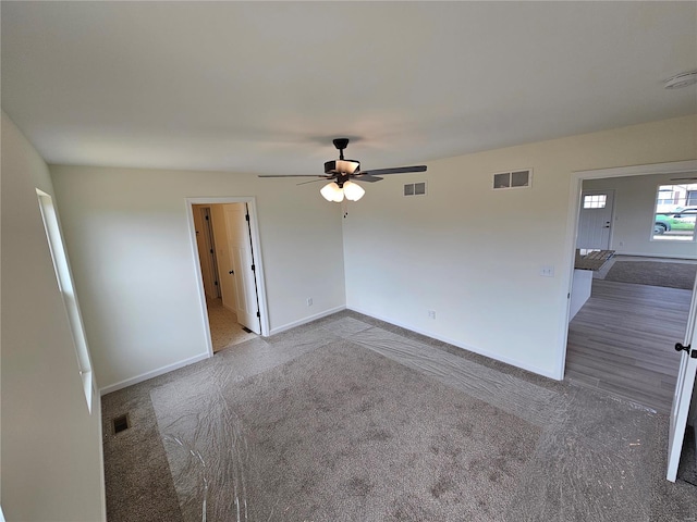 unfurnished room with ceiling fan and carpet