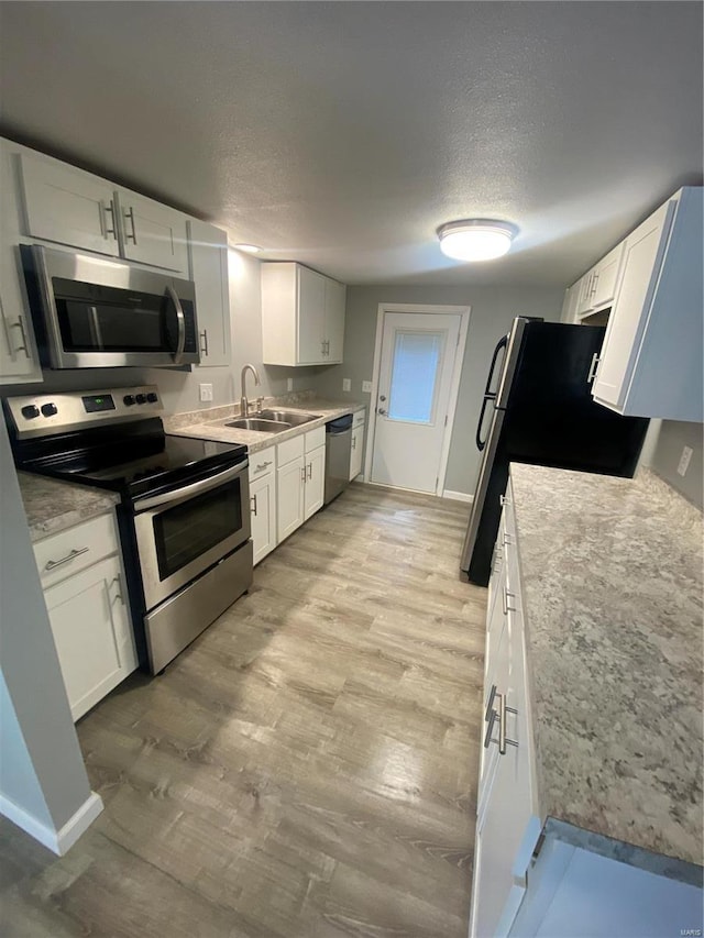 kitchen with sink, white cabinets, and stainless steel appliances