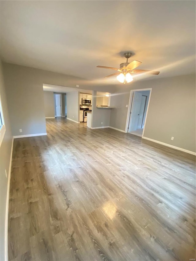 unfurnished living room featuring ceiling fan and wood-type flooring