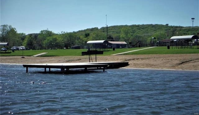 surrounding community with a water view and a yard