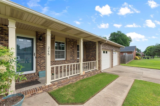 view of exterior entry featuring a porch, a lawn, and a garage