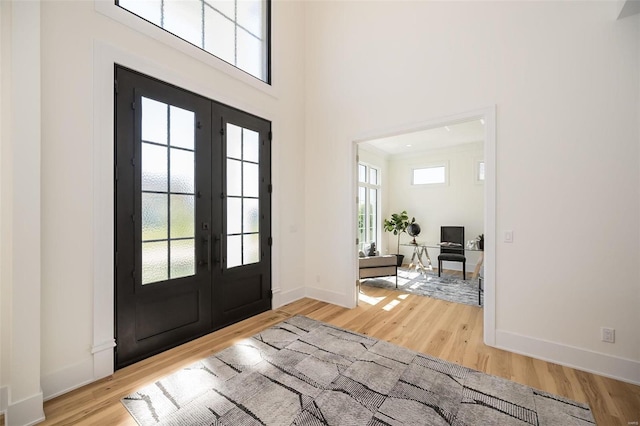 entrance foyer featuring a wealth of natural light, french doors, and light wood-type flooring