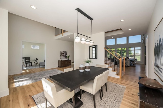 dining room featuring a high ceiling and light wood-type flooring