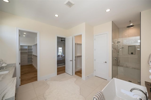 bathroom with tile floors, walk in shower, and ceiling fan