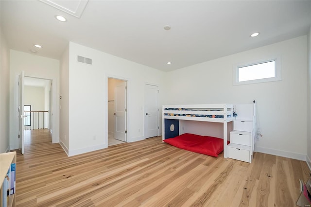 bedroom featuring ensuite bathroom and light wood-type flooring