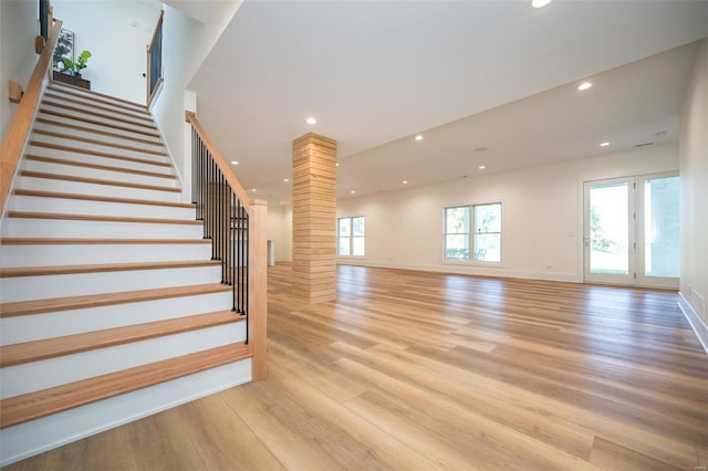 stairway with french doors and light wood-type flooring