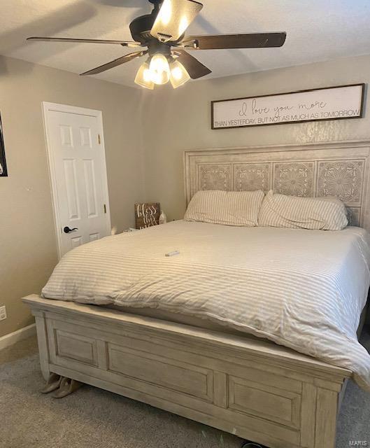 carpeted bedroom featuring ceiling fan and baseboards