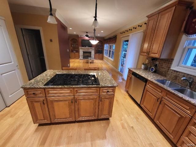 kitchen with stone countertops, black cooktop, stainless steel dishwasher, and light hardwood / wood-style flooring