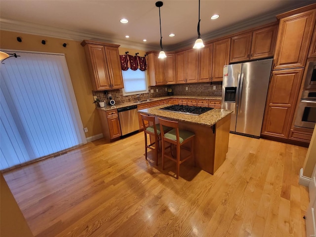 kitchen featuring stainless steel appliances, a center island, a breakfast bar area, and light wood-type flooring