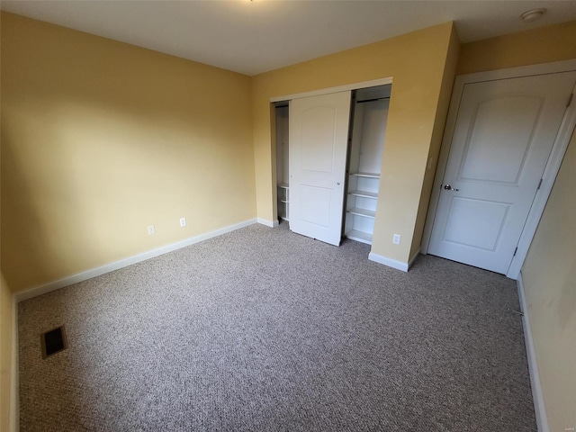 unfurnished bedroom featuring dark carpet and a closet