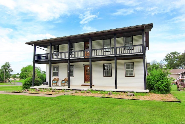 view of front facade with covered porch, a balcony, and a front yard