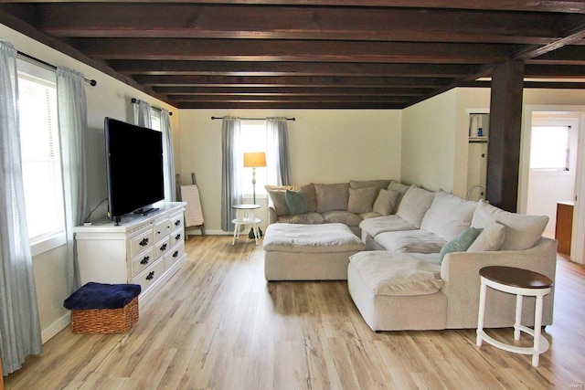 living room with beamed ceiling, plenty of natural light, and light hardwood / wood-style floors