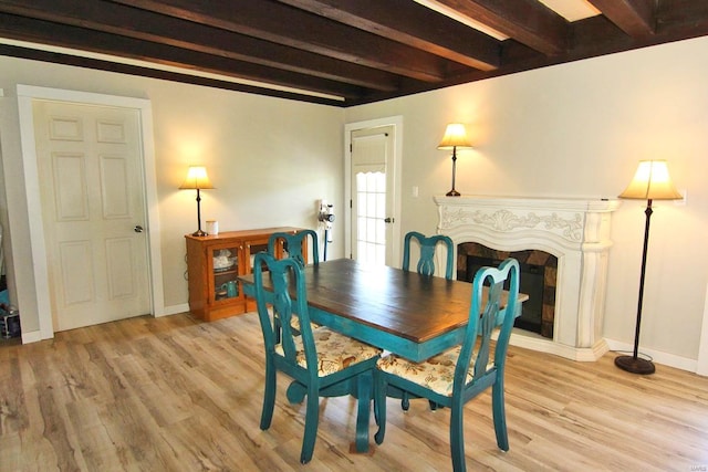 dining space featuring wood-type flooring and beam ceiling