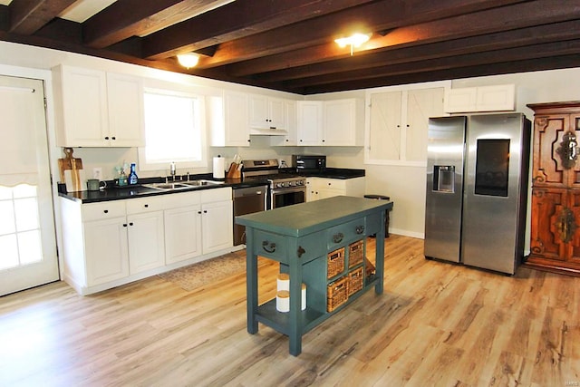 kitchen featuring plenty of natural light, stainless steel appliances, light hardwood / wood-style flooring, and beam ceiling