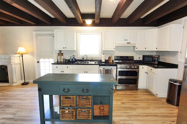 kitchen featuring white cabinetry, light wood-type flooring, beamed ceiling, double oven range, and sink