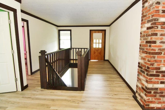 corridor featuring ornamental molding, light hardwood / wood-style floors, and brick wall